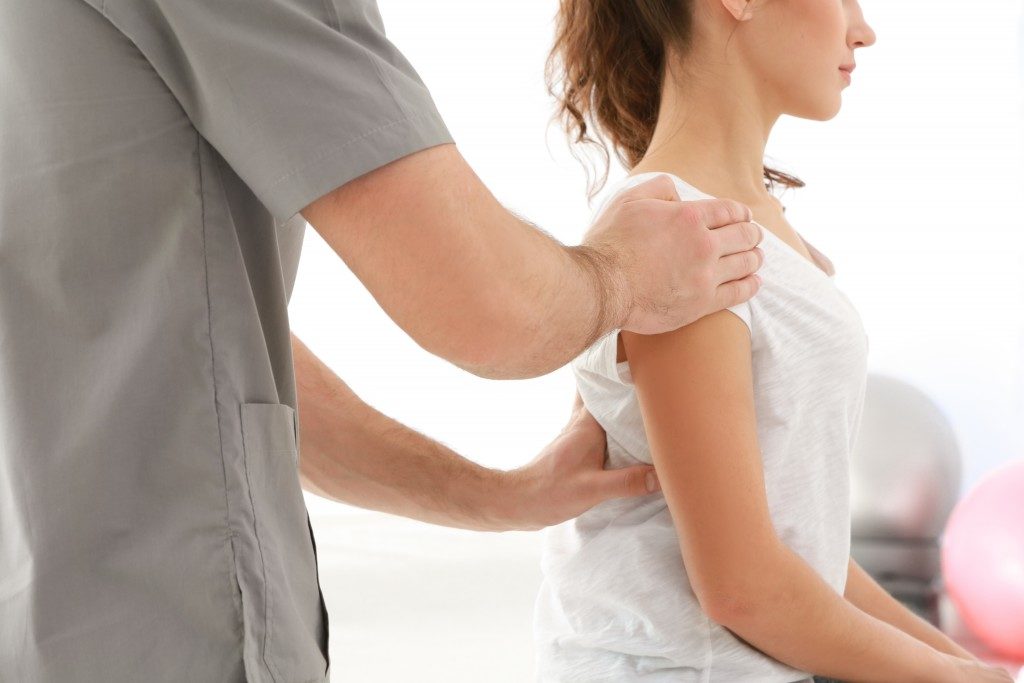 Chiropractor examining woman's back