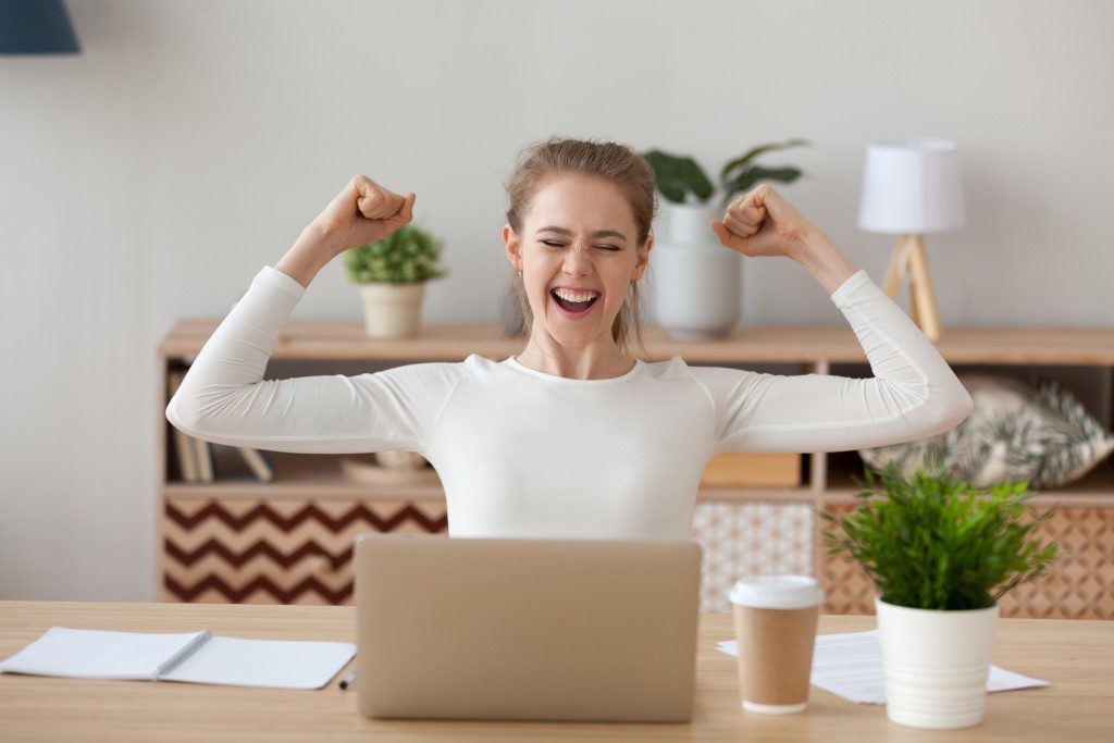 Excited woman looking at her laptop