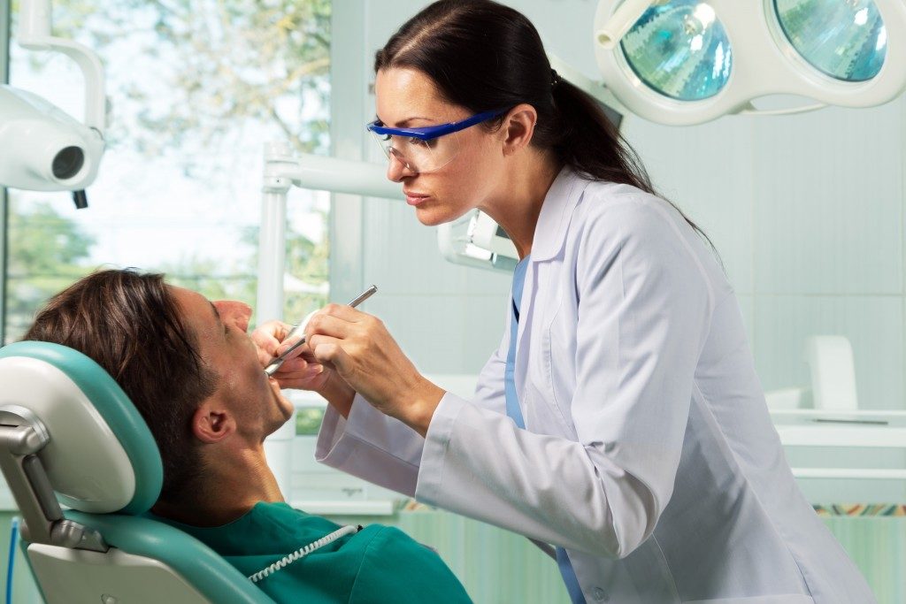 Dentist checking giving her patient a check up