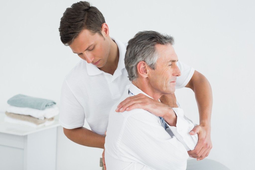physiotherapist doing adjustments to aged man