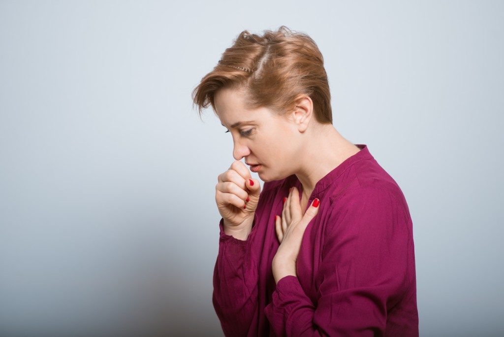 Woman coughing, feeling unwell