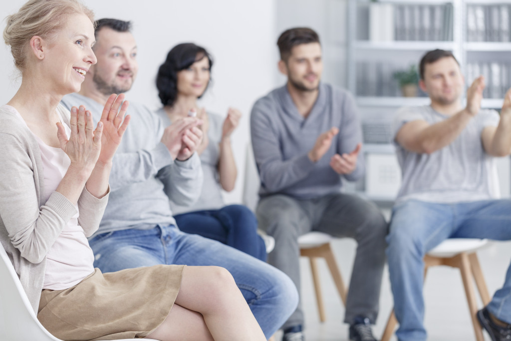support group meeting with people sitting together and clapping