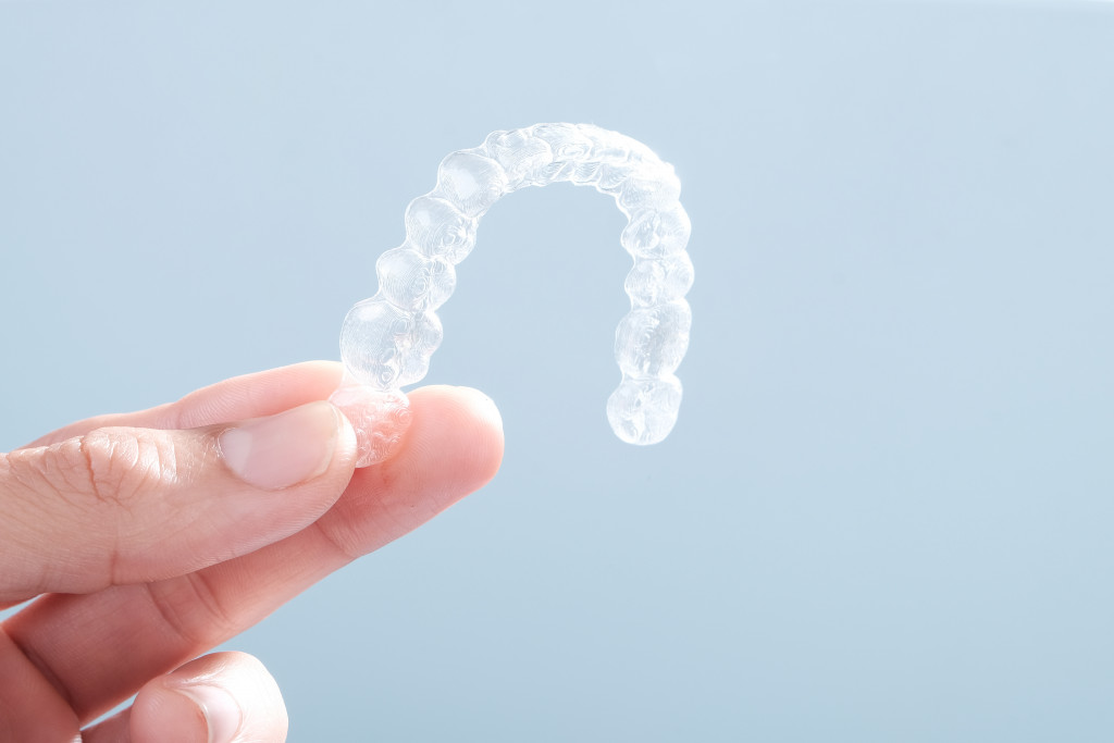 Closeup of a hand holding clear aligners