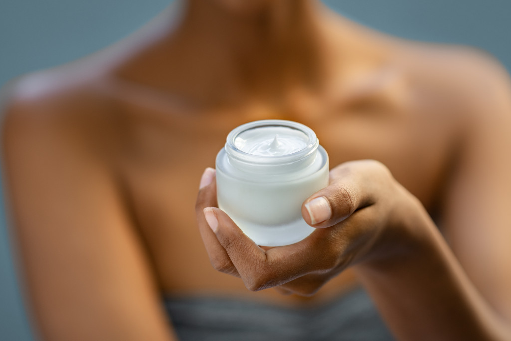 A woman holding a moisturizer jar