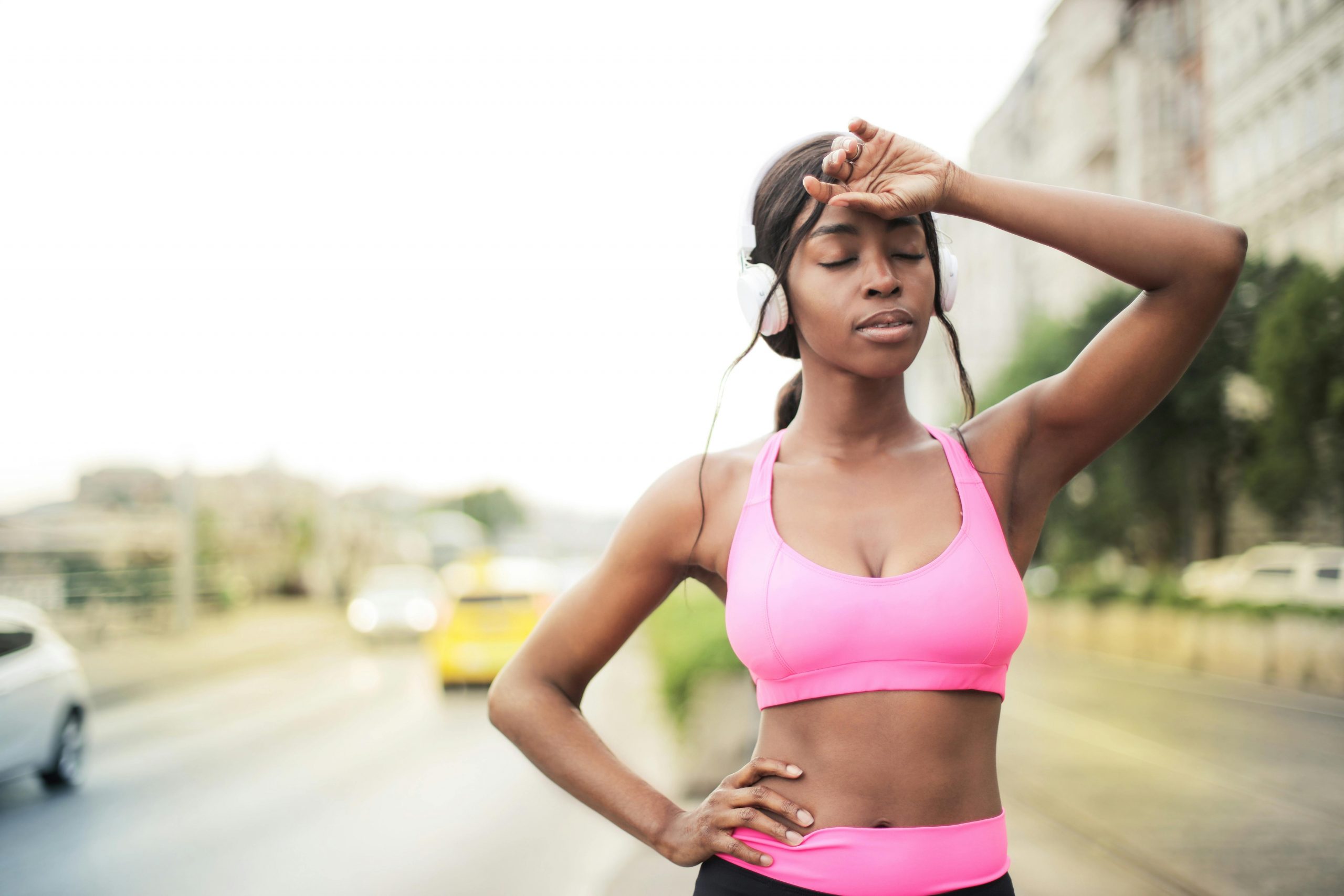 woman in pink workout clothes, looking exhausted